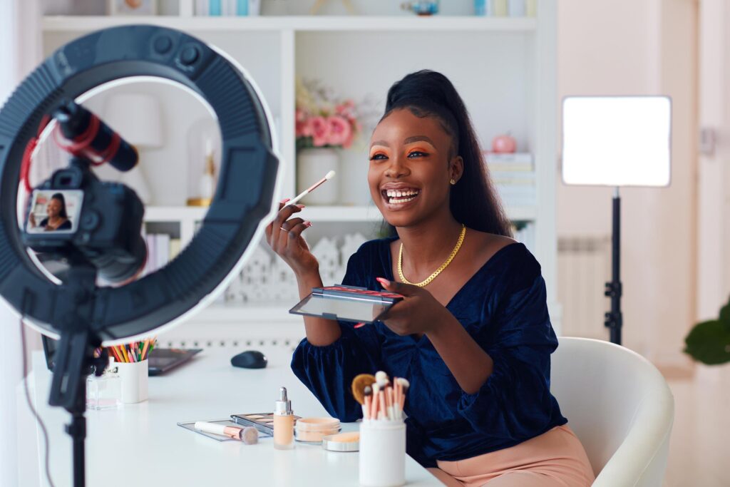 Woman smiling while filming a makeup tutorial